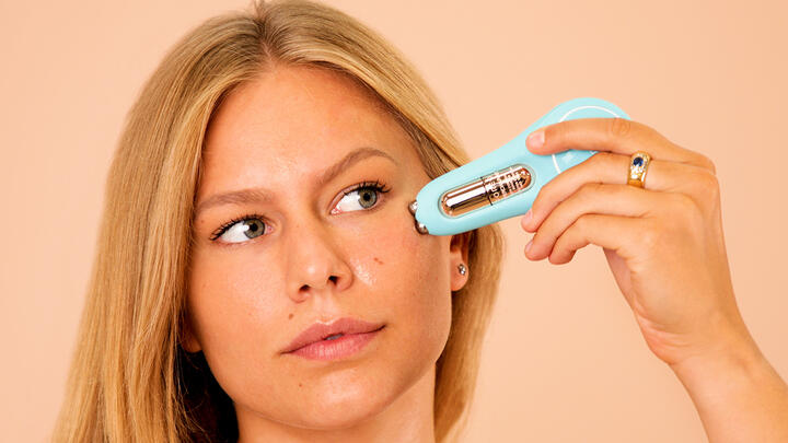 A model gliding BEAR 2 eyes & lips microcurrent device under the eye